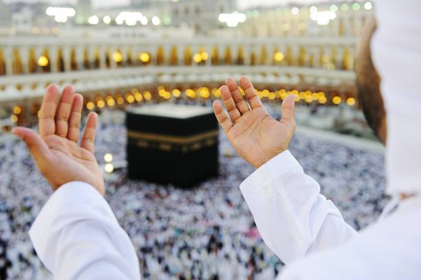 Muslim praying at Mekkah with hands up stock photo