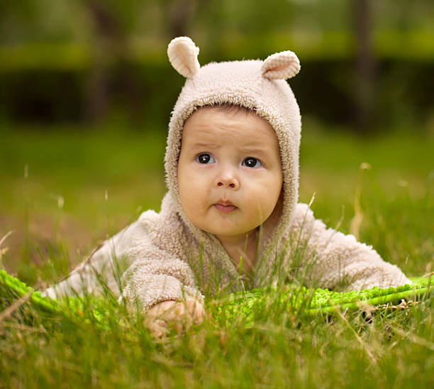 istock little girl sitting on green grass 178858636