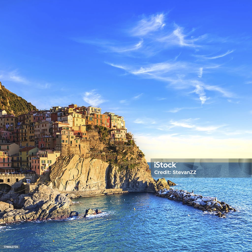 Manarola village, rocks and sea at sunset. Cinque Terre, Italy Manarola village on cliff rocks and sea at sunset., Seascape in Five lands, Cinque Terre National Park, Liguria Italy Europe. Square format. Architecture Stock Photo