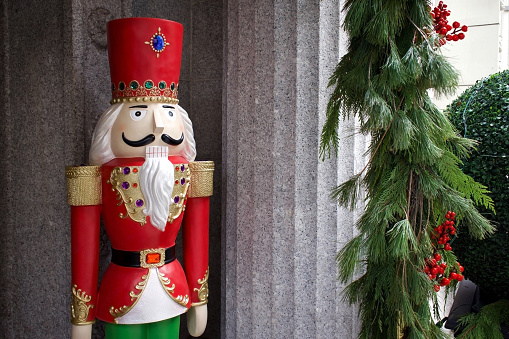 Wooden Nutcracker inside a decorated christmas tree.