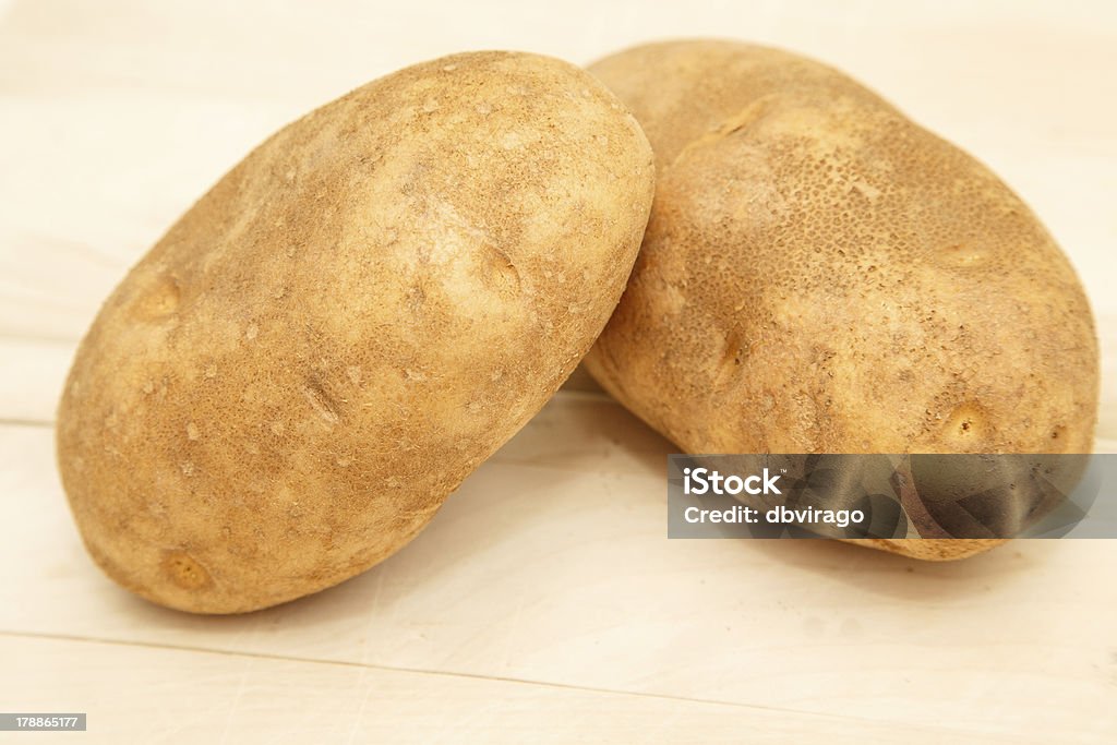 Deux ensemble de pommes de terre sur la planche à découper pour faire cuire au four - Photo de Aliment cru libre de droits