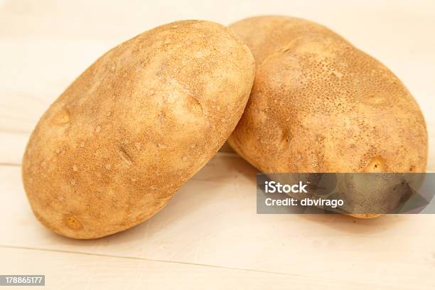 Due Interi Patate Sul Tagliere Per Cuocere Al Forno - Fotografie stock e altre immagini di Carboidrato - Cibo