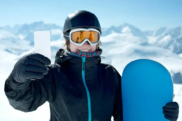 Photo of Snowboard girl with blank card smiling