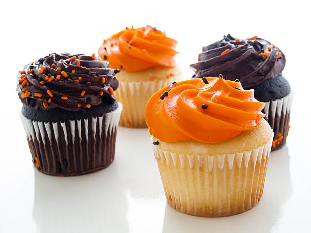 Cupcakes Halloween orange and black cupcakes on white background. halloween cupcake stock pictures, royalty-free photos & images