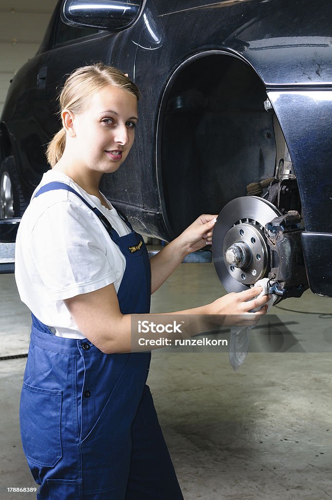 Tirocinante nel garage pulizia freni - Foto stock royalty-free di Mecatronica