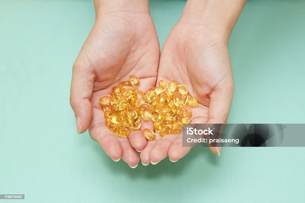 Vitamine Omega 3 capsules d'huile de poisson sur un coup de main - Photo de Complément vitaminé libre de droits