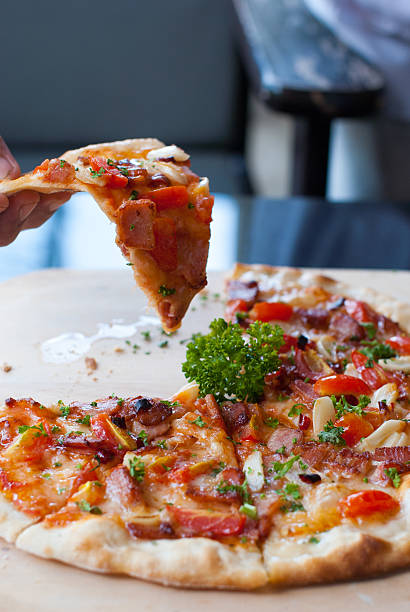 istock slice of pizza in hand 178872704