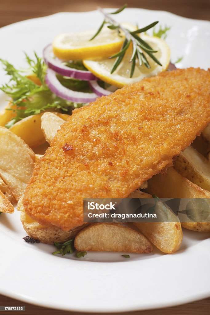 Breaded fish steak Breaded fish steak with baked potato served on a plate Baked Stock Photo