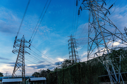 Big electrical towers of high tension for the distribution of electricity on a blue sky in sport field.  Bangkok,Thailand