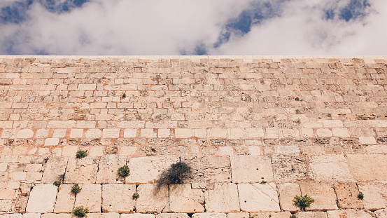 Low angle view of the Western Wall, with blue sky and clouds