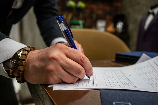 men hand is writing to paper close up horizontal small business still
