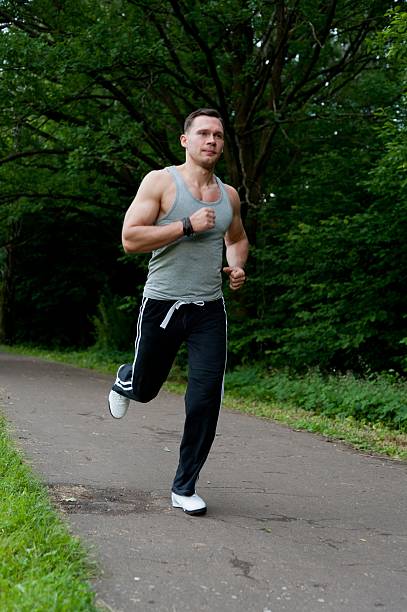 istock Man in black pants runs on the road 178876902