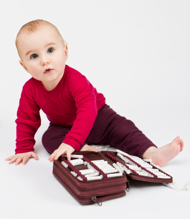 young child in red shirt with many homeopathic globule ordered by name. No product names, just common names of homeopathic medicine