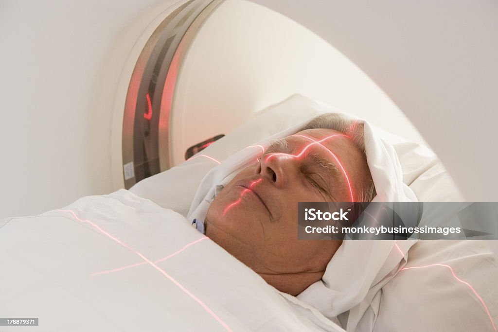 Patient Having A Computerized Axial Tomography (CAT) Scan Patient Having A Computerized Axial Tomography (CAT) Scan In Hospital Room Lying Down 70-79 Years Stock Photo