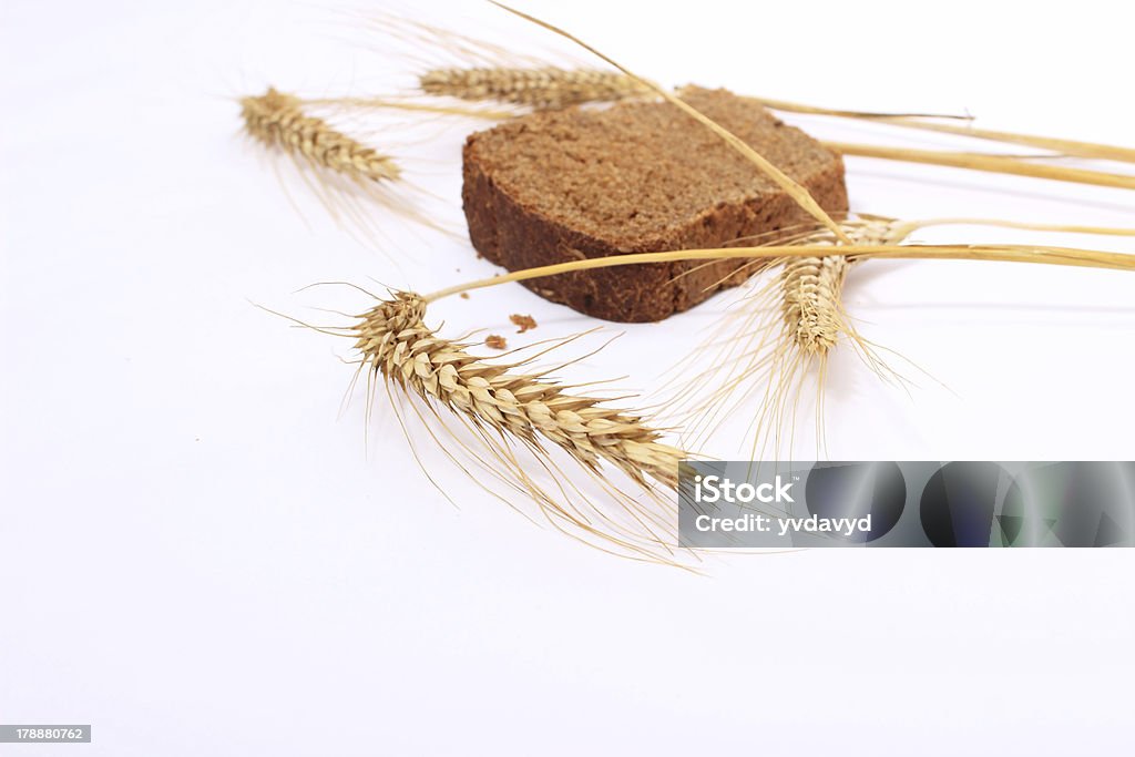Panino di pane e gambi di spighe di grano su sfondo bianco, - Foto stock royalty-free di Brioche - Dolci