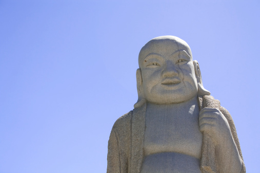 One isolated buddah estatue isolated in the blue sky