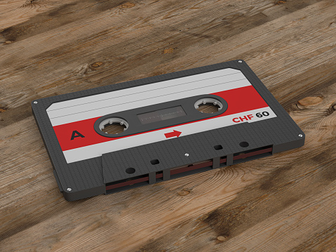 Cassette tape on a wooden background. 3d illustration.