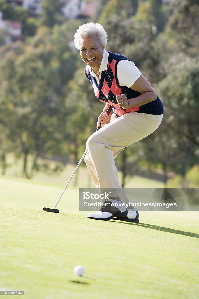 A woman playing a game of golf Woman Playing A Game Of Golf  On Her Own Smiling Golf Stock Photo