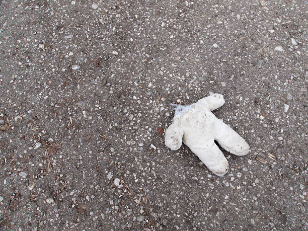 istock Abandoned Teddy-bear lying headless on concrete ground 178885799