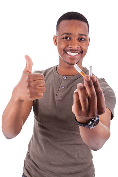young african american man showing a broken cigarrillo - african descent addiction african ethnicity rudeness fotografías e imágenes de stock