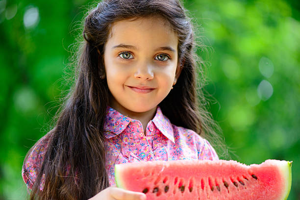 Cute hispanic girl eating watermelon