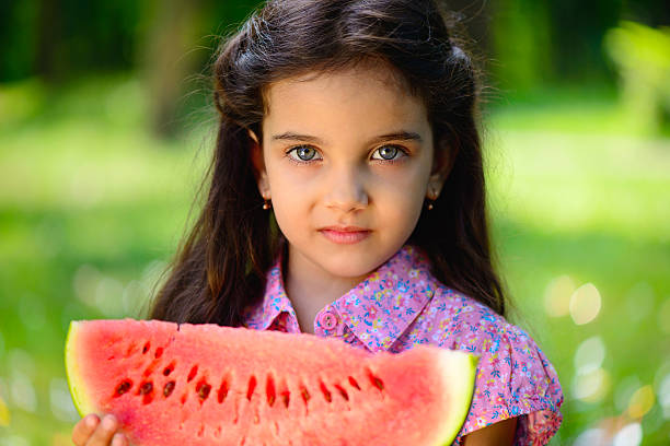 istock Cute hispanic girl eating watermelon 178886899
