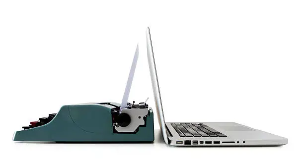 Photo of A close-up of a laptop and an old typewriter