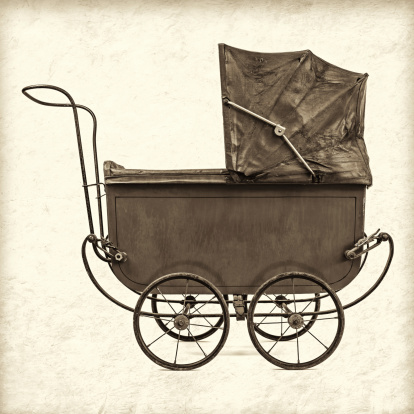 Retro styled sepia image of a vintage baby stroller