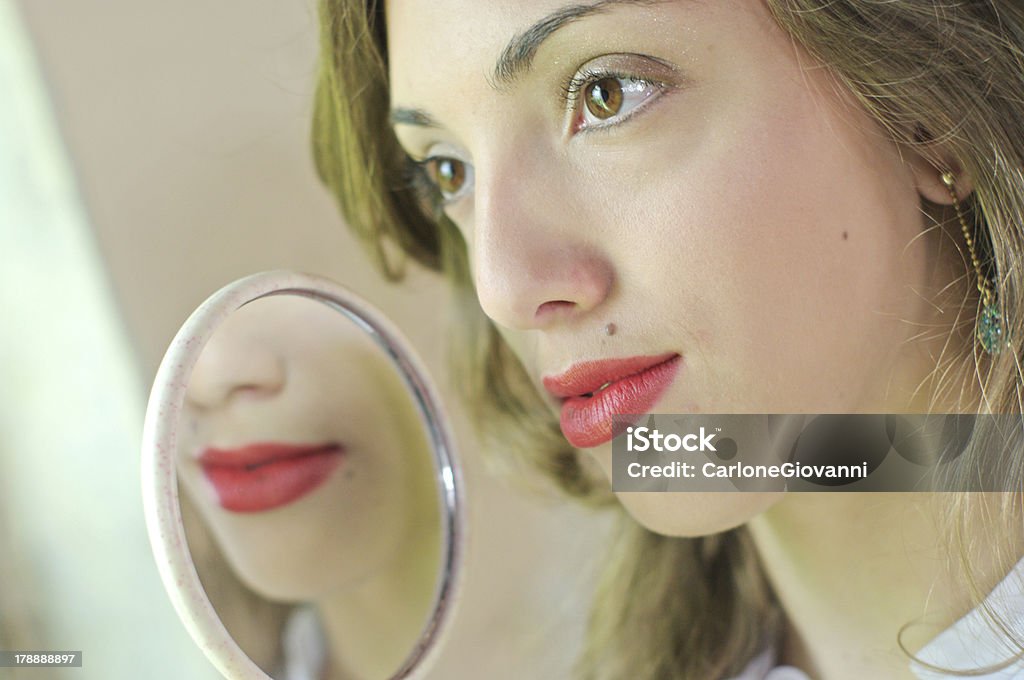 赤い口紅をつけ、鏡で見ている - ファッションのロイヤリティフリーストックフォト