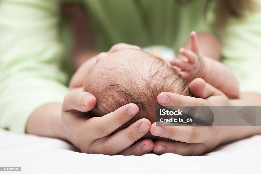 Cute sleeping newborn baby child on mother hands Loving mother hand holding cute sleeping newborn baby child Adult Stock Photo