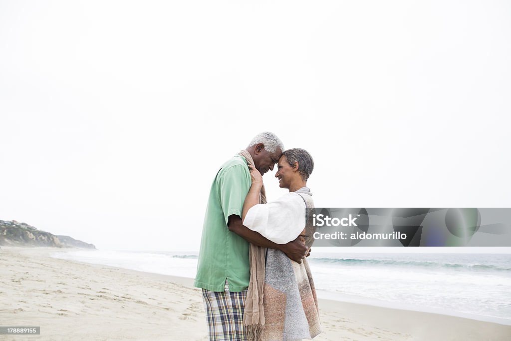 Senior coppia in amore godendo la spiaggia - Foto stock royalty-free di Abbracciare una persona