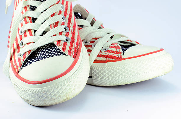Pair of shoes with american stars and stripes decoration Pair of shoes with american stars and stripes decoration on white background usa flag shoes stock pictures, royalty-free photos & images