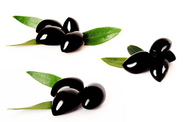 Black olives with green leaves on white stock photo