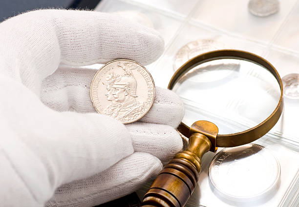 old silver coin old silver coin and  magnifying glass coin collection stock pictures, royalty-free photos & images