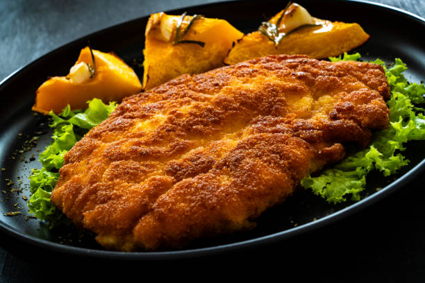 istock Breaded fried pork chop with baked pumpkin on wooden table 1788920519