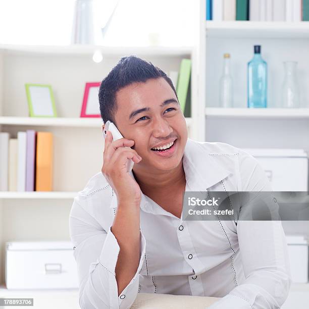 Smiling Young Man In White Shirt Taking On A Phone Stock Photo - Download Image Now - Adult, Adults Only, Asian and Indian Ethnicities