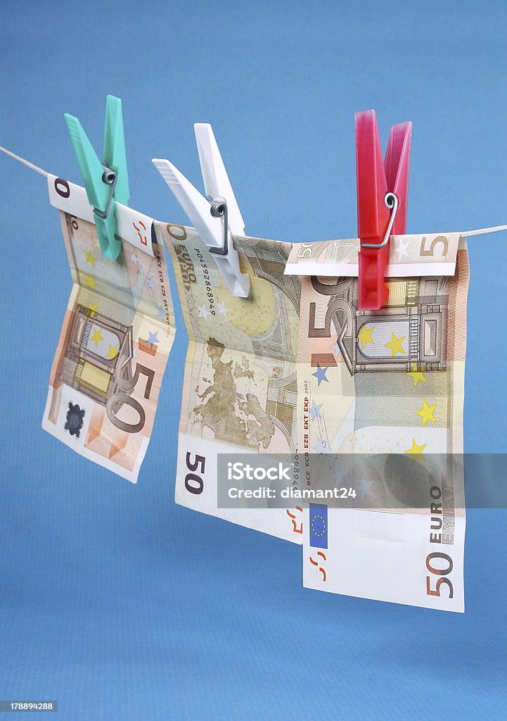 Laundering of fifty euro bills Money laundering from fifty euro notes on a blue background European Union Currency Stock Photo
