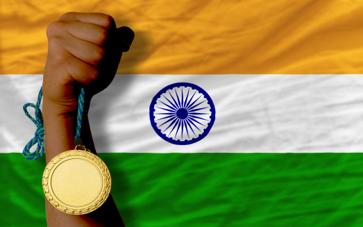 Winner holding gold medal for sport and national flag of  india