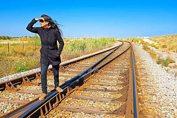 junge frau mit ihren koffer warten auf railroad track - leaving loneliness women railroad track stock-fotos und bilder