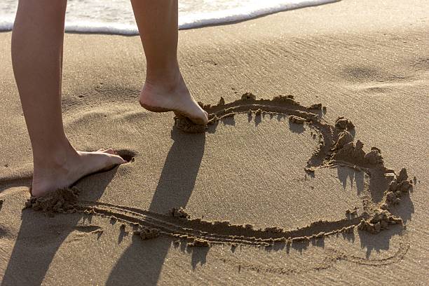Drawing an hearth in the sand stock photo