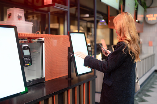 A young woman checks in using the self service kiosk