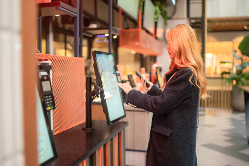 A young women uses a self service kiosk