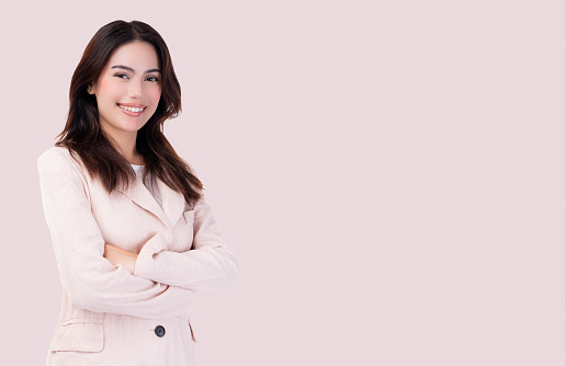 Young Asian confident Business woman arms crossed portrait isolated on pink background Businesswoman in pink suit crossed arms Young confident smiling Asian business lady leader looks at camera