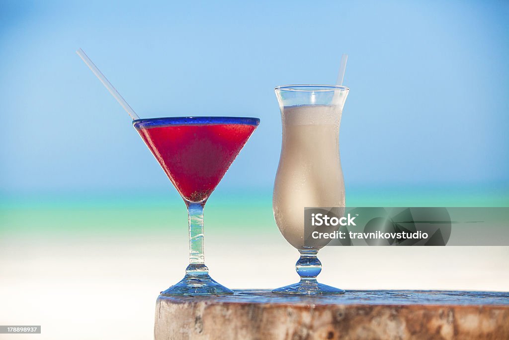 Branco pina colada e margarita de vermelho na praia de mesa - Foto de stock de Areia royalty-free