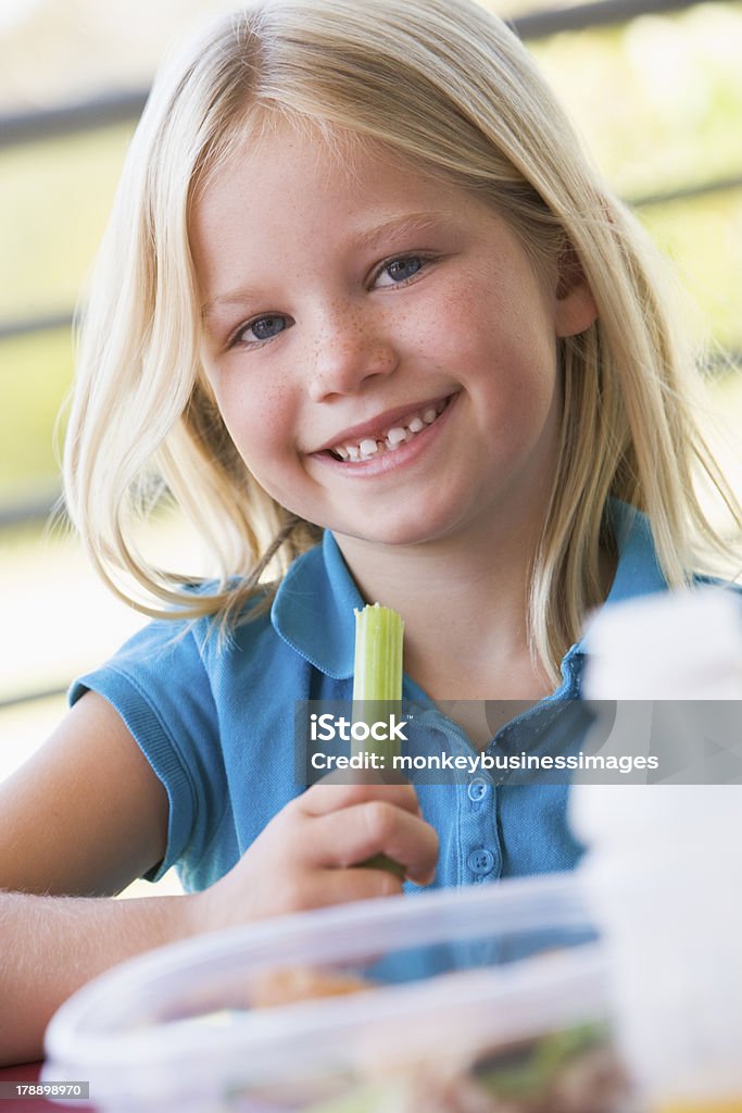 Girl eating lunch at kindergarten Girl eating lunch at kindergarten outdoors smiling to camera Child Stock Photo