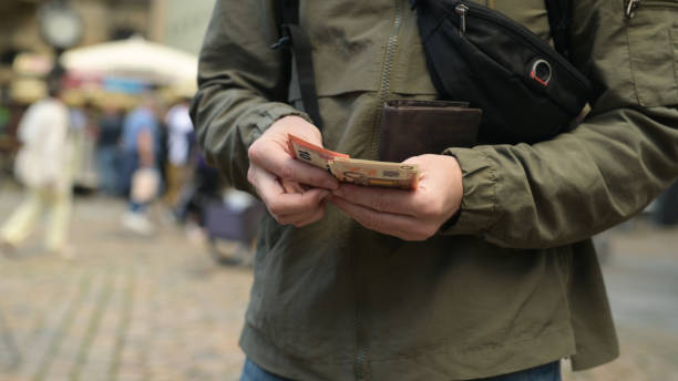 istock Man On Street Pulls Out Euro From Wallet 1788991255