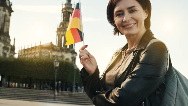 istock Young Woman Smiles With German Flag In Hand 1788991259