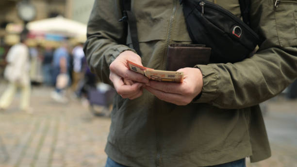 istock Man On Street Pulls Out Euro From Wallet 1788991281