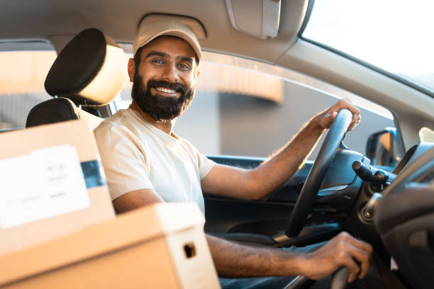istock Cheerful Arab Guy Courier Sitting In Car Among Carton Boxes 1788993500