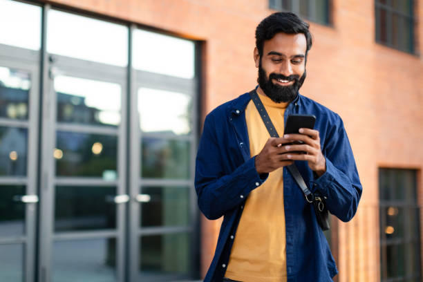 istock Cheerful indian stylish guy using smartphone in urban city area 1788993532